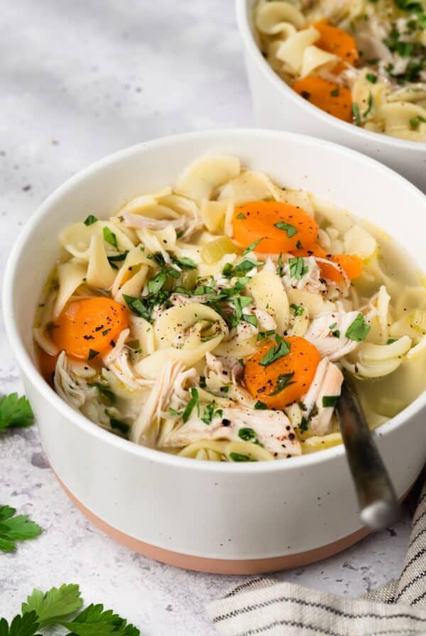 side view of a bowl of Instant Pot chicken noodle soup.